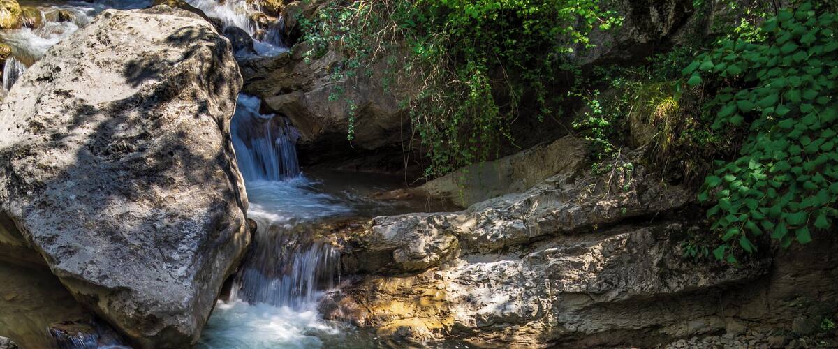 A flowing river with rocks and a waterfall.