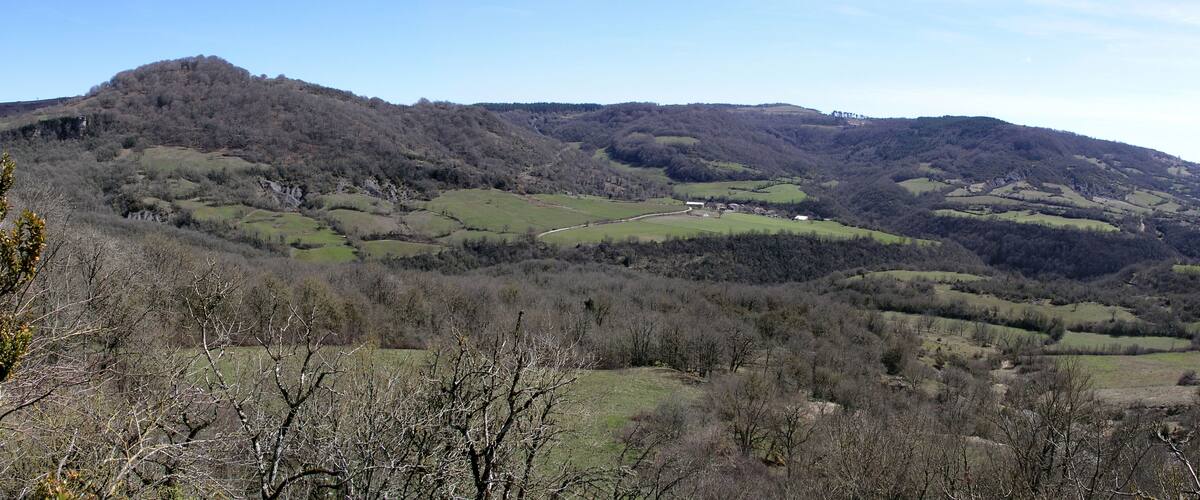 Rolling hills, a valley, and a small building in the distance.