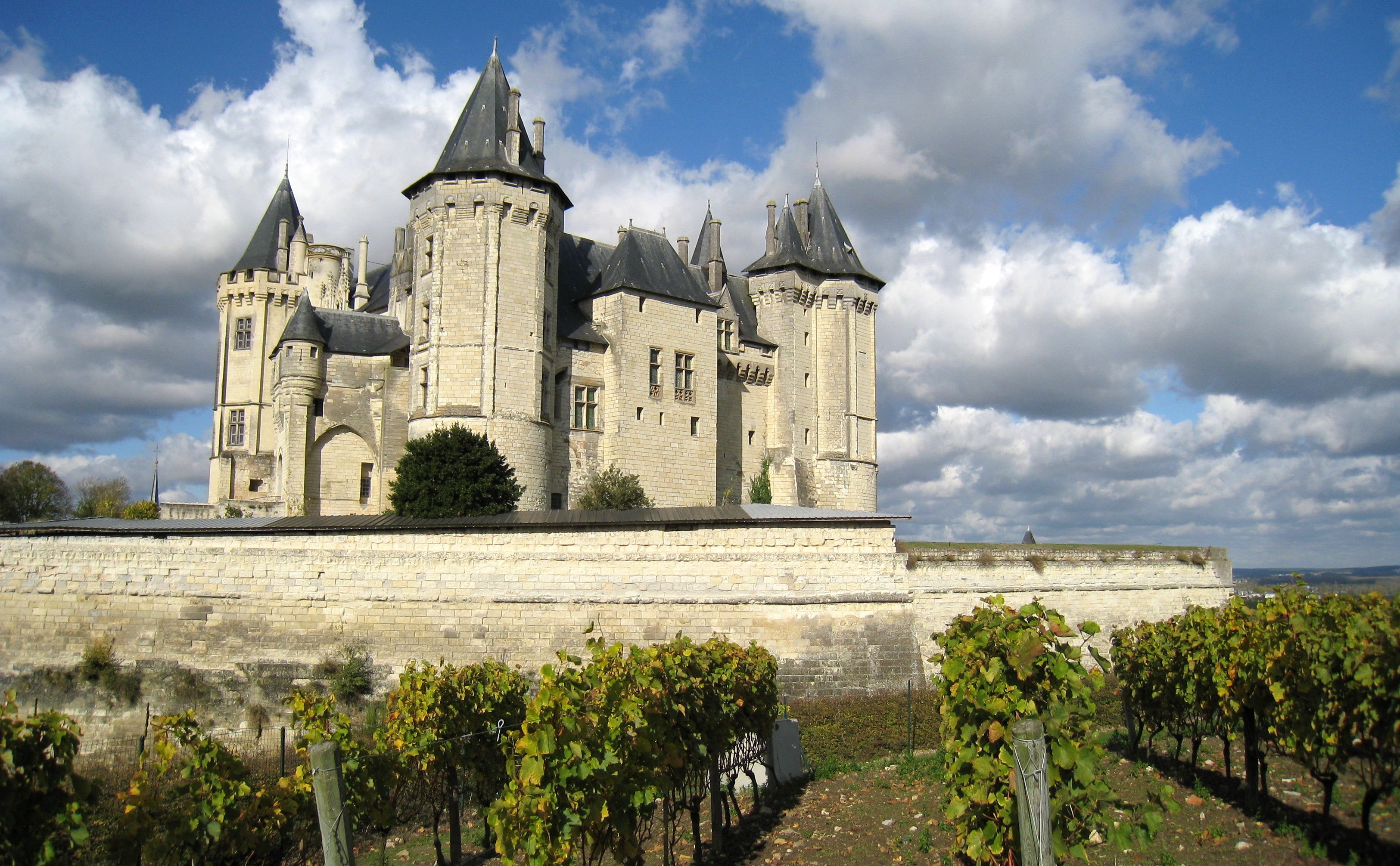 A historic castle with multiple towers and a surrounding wall.
