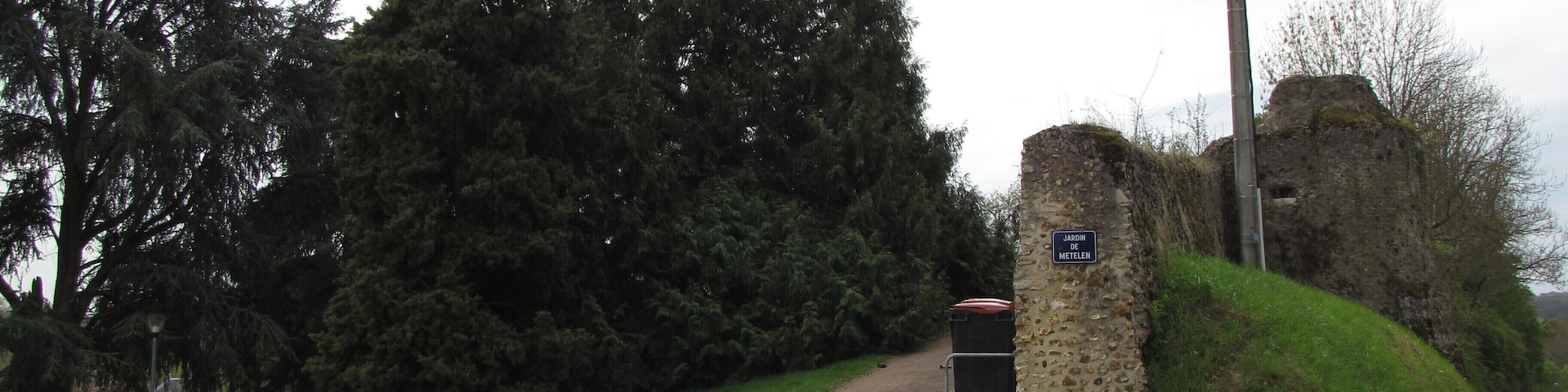 This garden is located behind the mairie (hôtel de ville, or town hall). It has two entrances : one to the north side towards the Avenue du Chemin Blanc, the other to the south behind the Place de l'Hôtel de Ville. This view is from the north entrance. On its north and west sides there are remains of the old town's fortifications, with a tower at the north-west corner (visible from the Avenue du Chemin Blanc). The war monument for the 1914-18 war, with a nice statue of a winged République allegory, is at the south entrance of the Metelen garden.