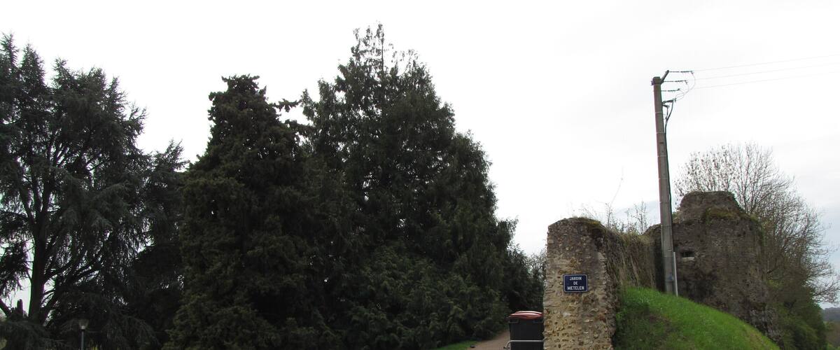 A rural road leading to a stone structure with a sign reading "JAGGIN METELEN".