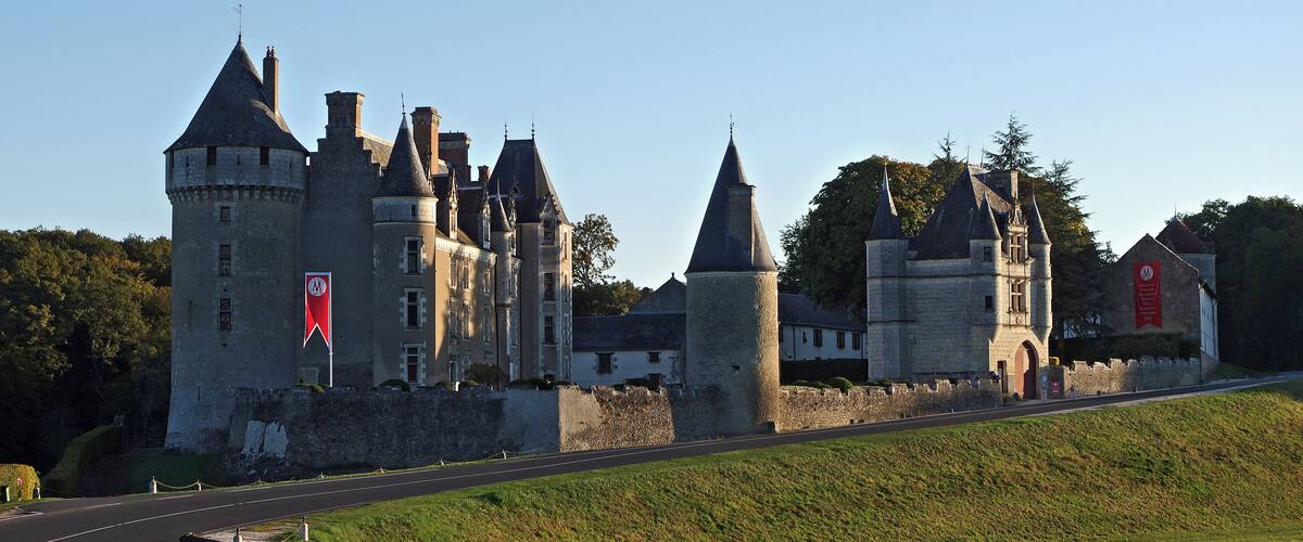 A historic castle with multiple towers and a well-maintained road in the foreground.