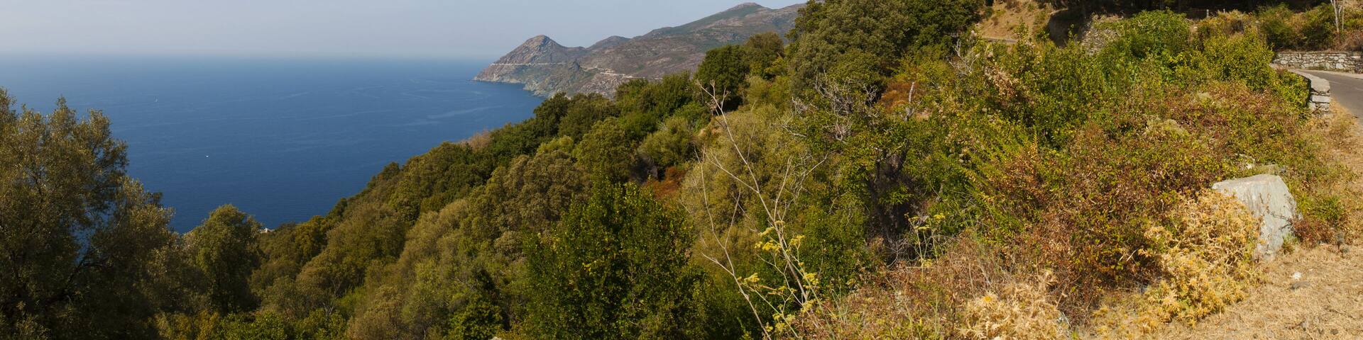 Capo Corso, Corsica, 28/08/2017: il Mar Mediterraneo, la macchia mediterranea e il campanile bianco di Canari, un ex faro costruito per segnalare la costa ai marinai