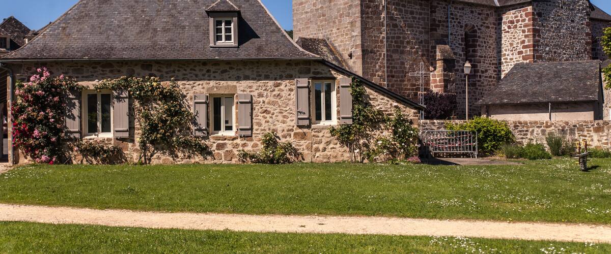 A stone building with a steep roof and a bell tower.