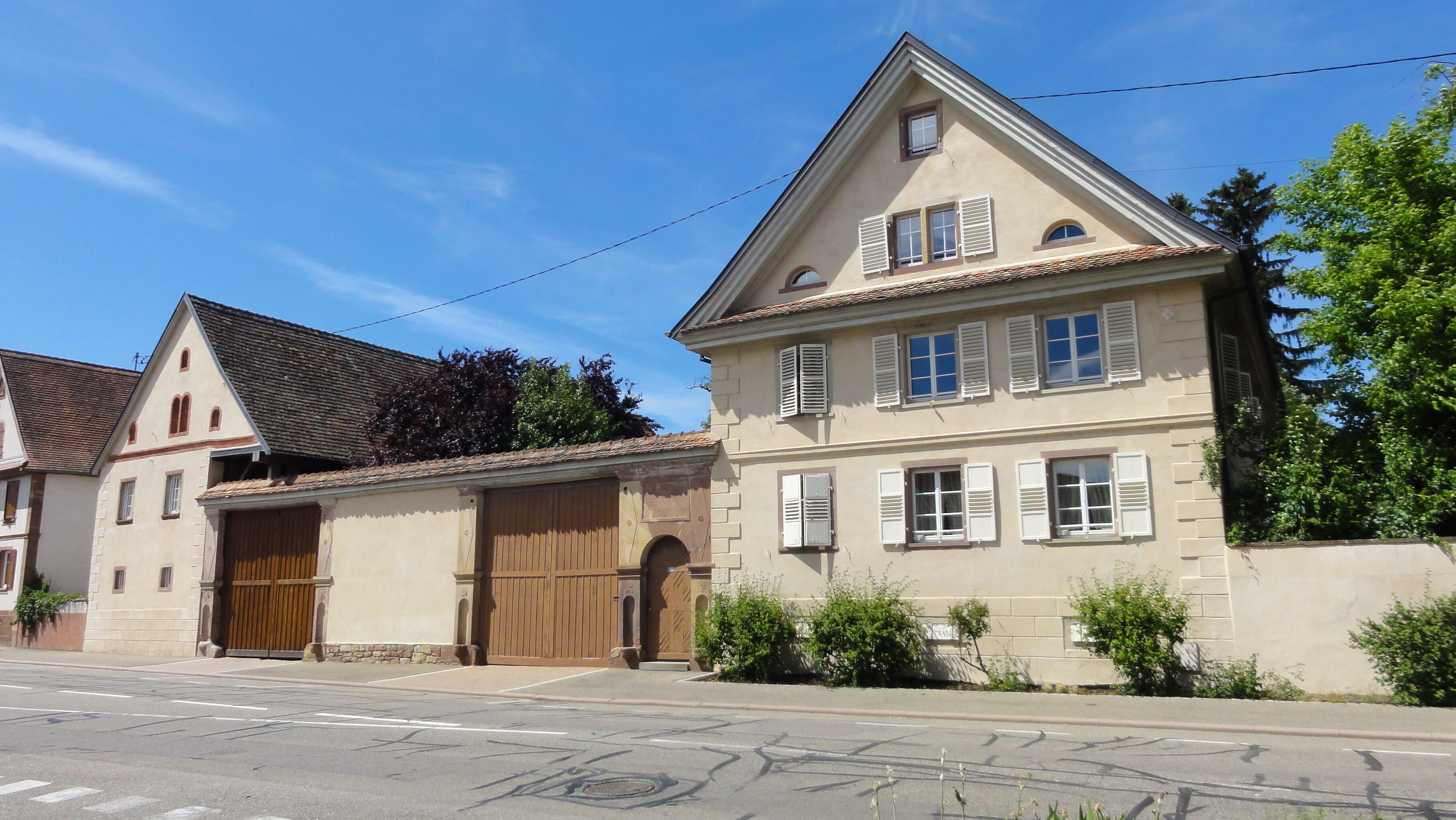 A two-story house with a large garage and a sloped roof.