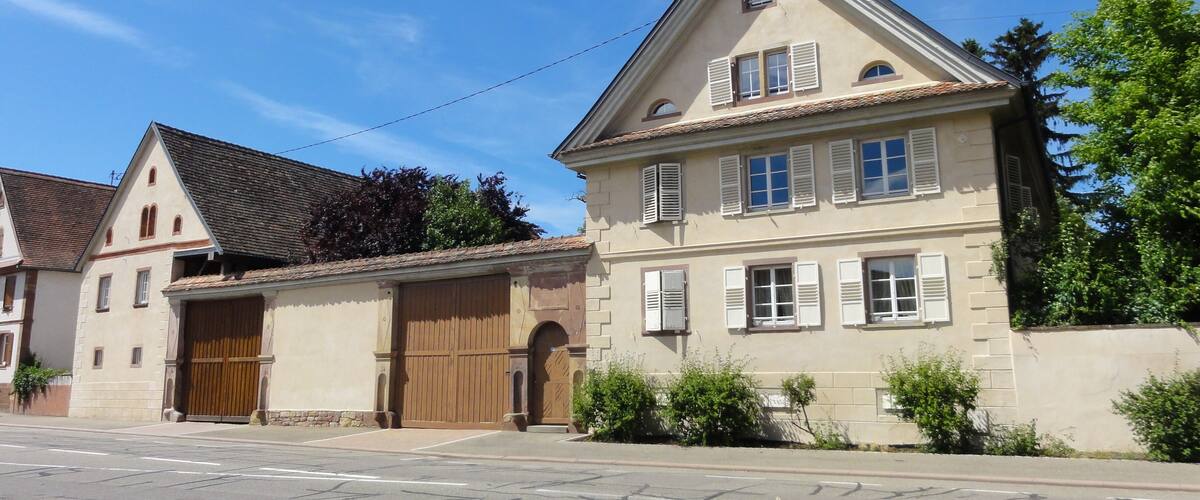A two-story house with a large garage and a sloped roof.