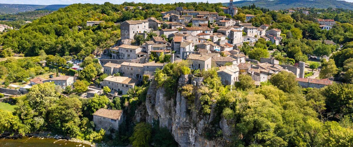 A historic town nestled on a cliffside with a river at its base.