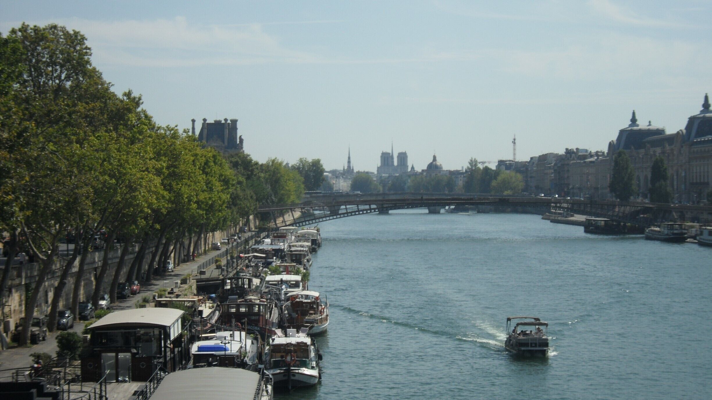 A river with boats, a bridge, and buildings in the background.