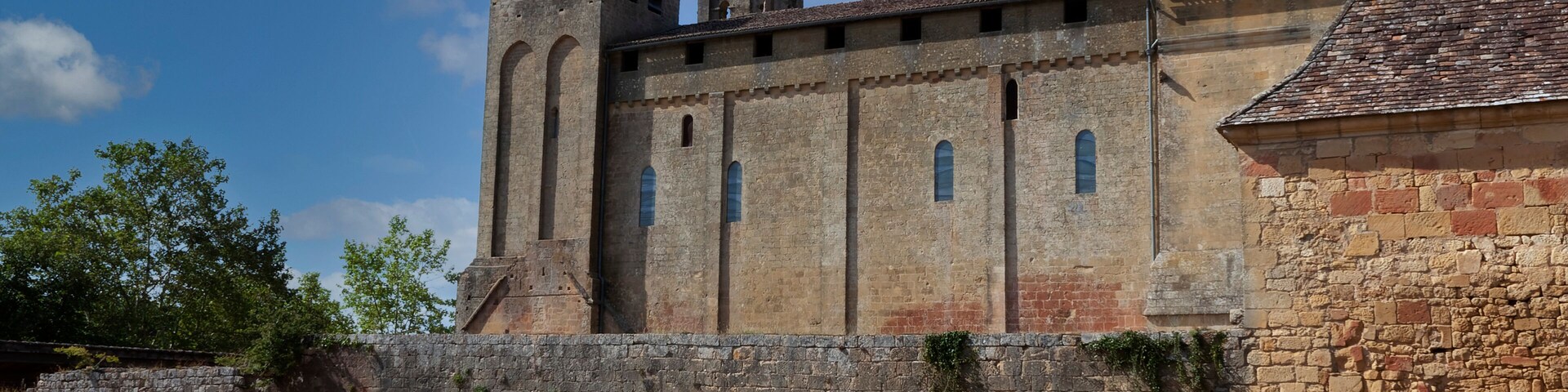 An ancient stone building with a tower and arched windows.
