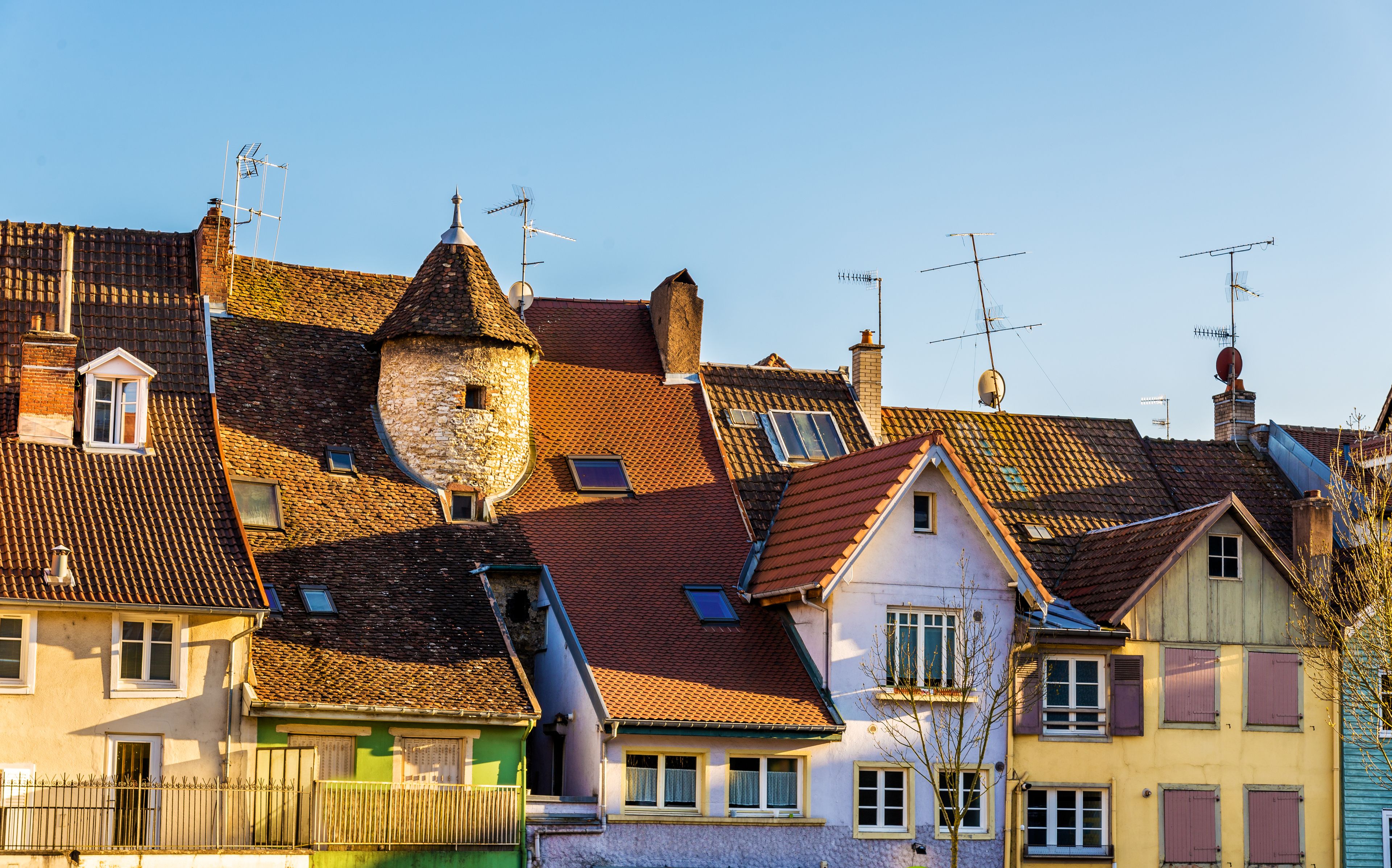 Eine Reihe traditioneller europäischer Gebäude mit geneigten Dächern und mehreren Antennen.