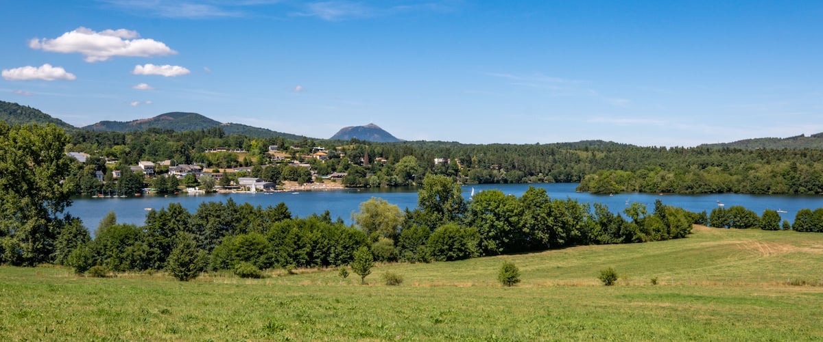 A lake surrounded by hills and trees, with a small town in the background.