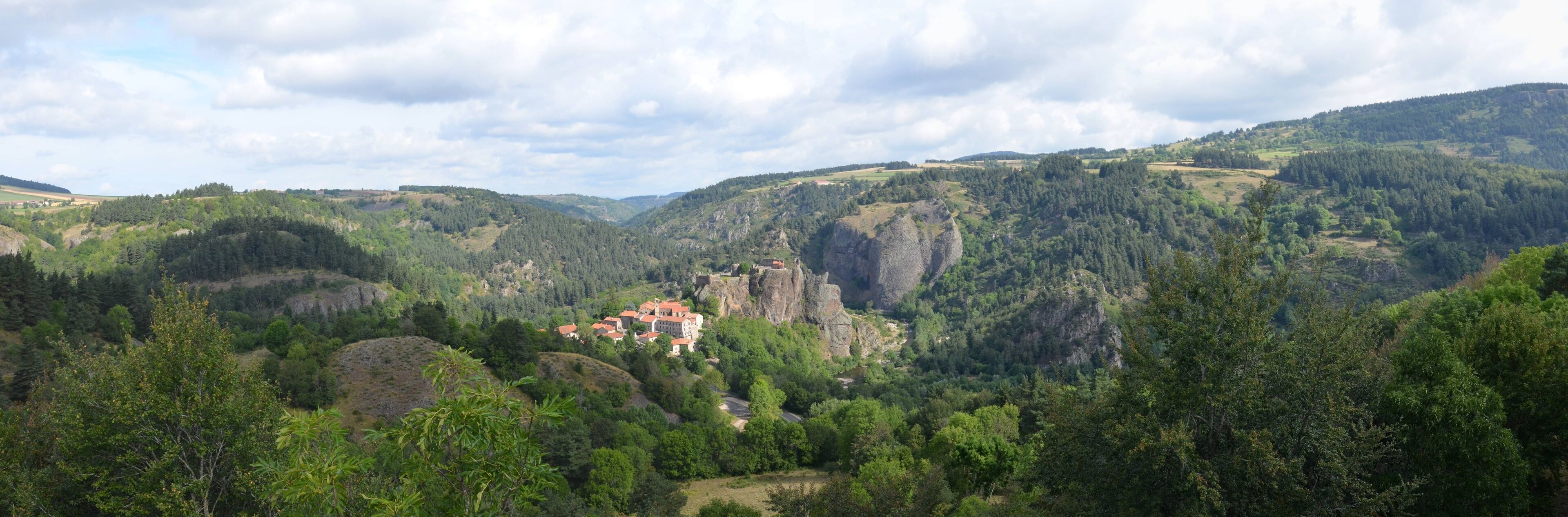 A mountainous landscape with a castle on a hill.