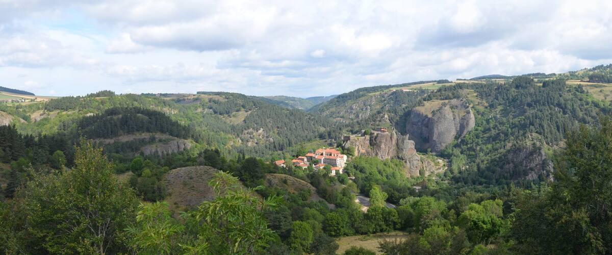 A mountainous landscape with a castle on a hill.