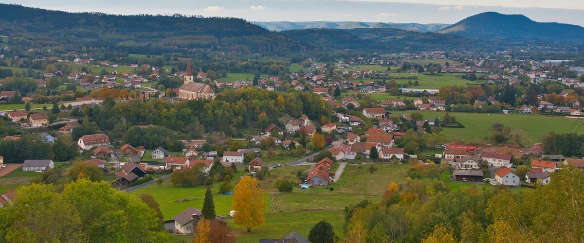 A town with a prominent church, rolling hills, and a mix of residential and agricultural land.