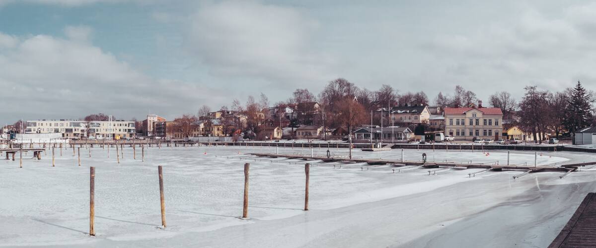 A frozen waterfront with buildings in the background.