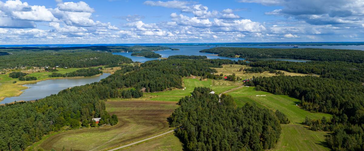 A landscape with a lake, forested areas, and a small village.