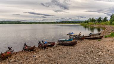 panorama view of many wooden motorboats used for salmon fishing on the banks of the Tornionjoki River in Finnish Lapland