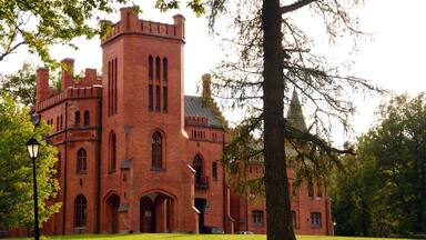 A large brick building with arched windows and a tower.