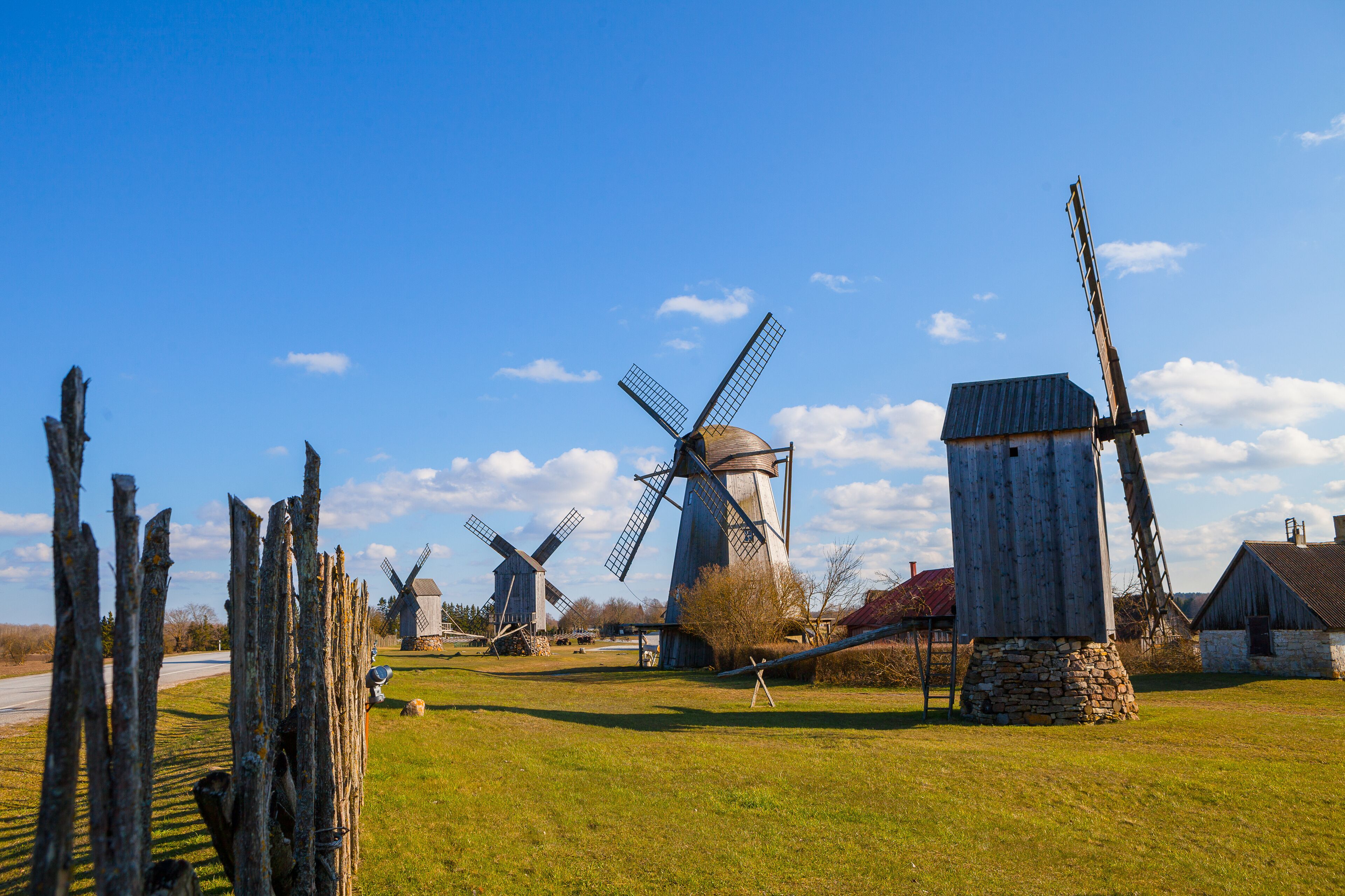 A rural landscape with several windmills and a wooden structure.