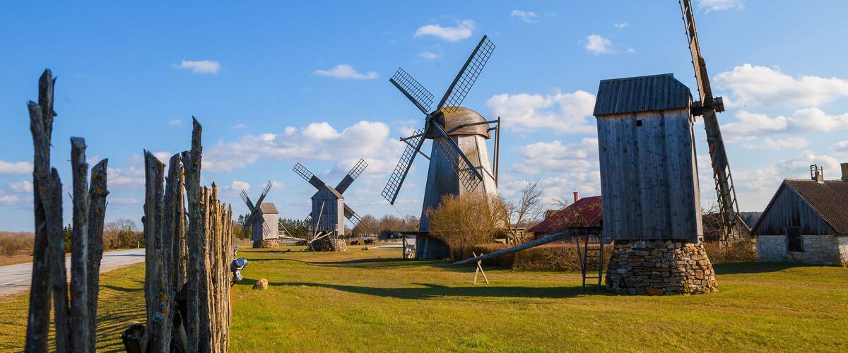 A rural landscape with several windmills and a wooden structure.