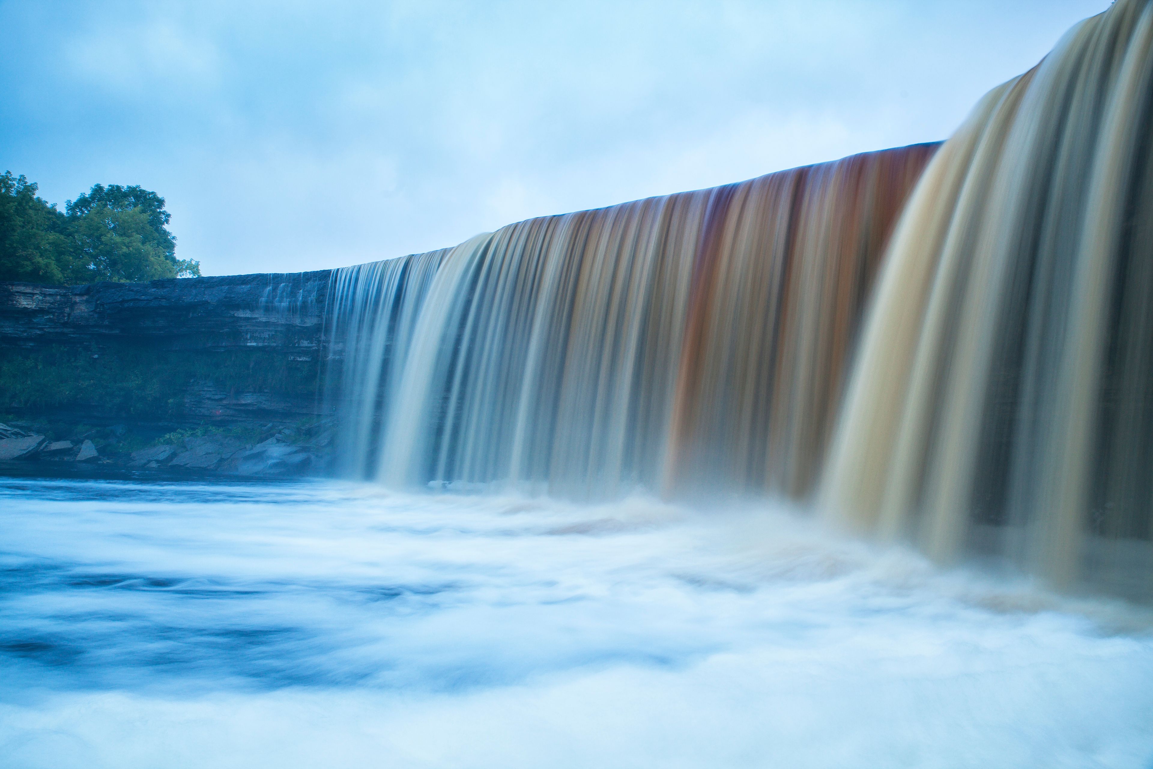 Ein Wasserfall stürzt über eine felsige Klippe.