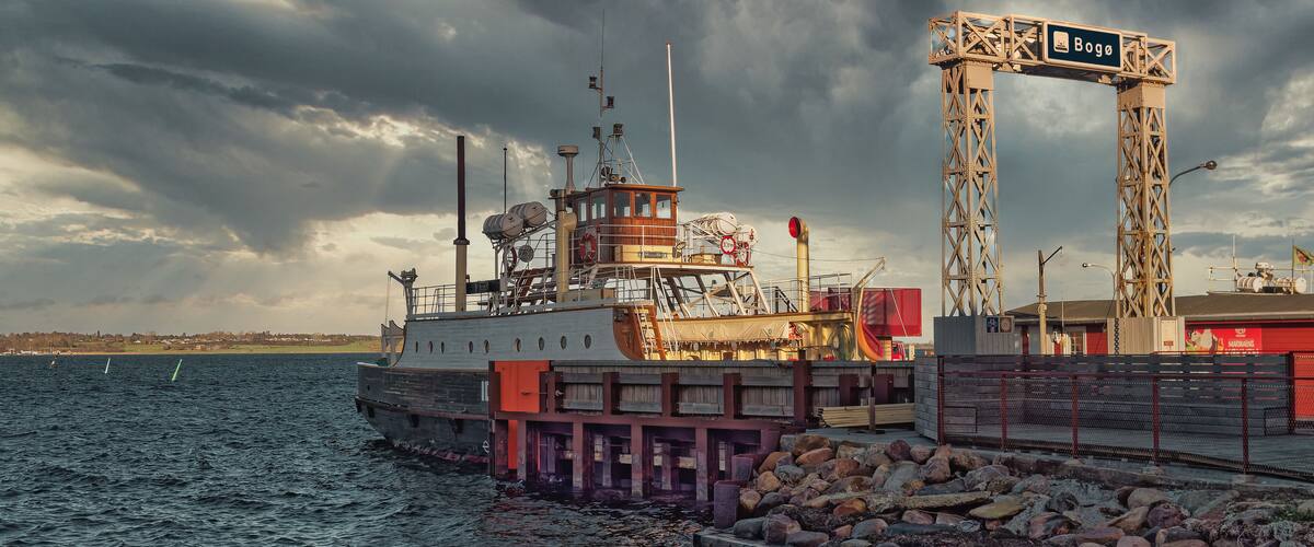 A ship docked at a pier with a sign reading "Bogo".