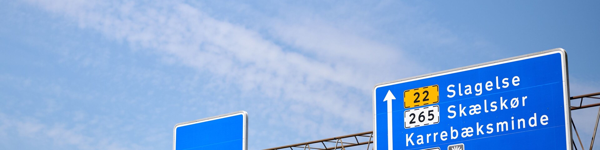 A highway sign with directions to Slagelse, Skælsker, and Karrebæksminde.