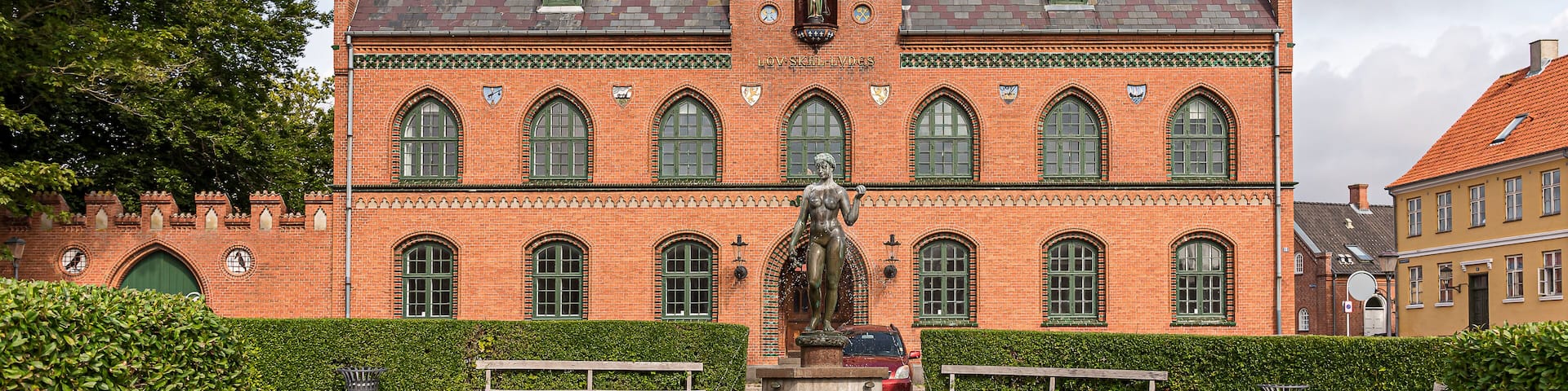 A historic building with a statue in front.