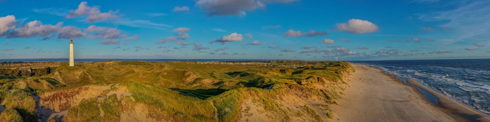 Panoramic aerial view of Lyngvig lighthouse on wide dune of Holmsland Klit with beach view on the west coast of Jutland, by Hvide Sande, Denmark