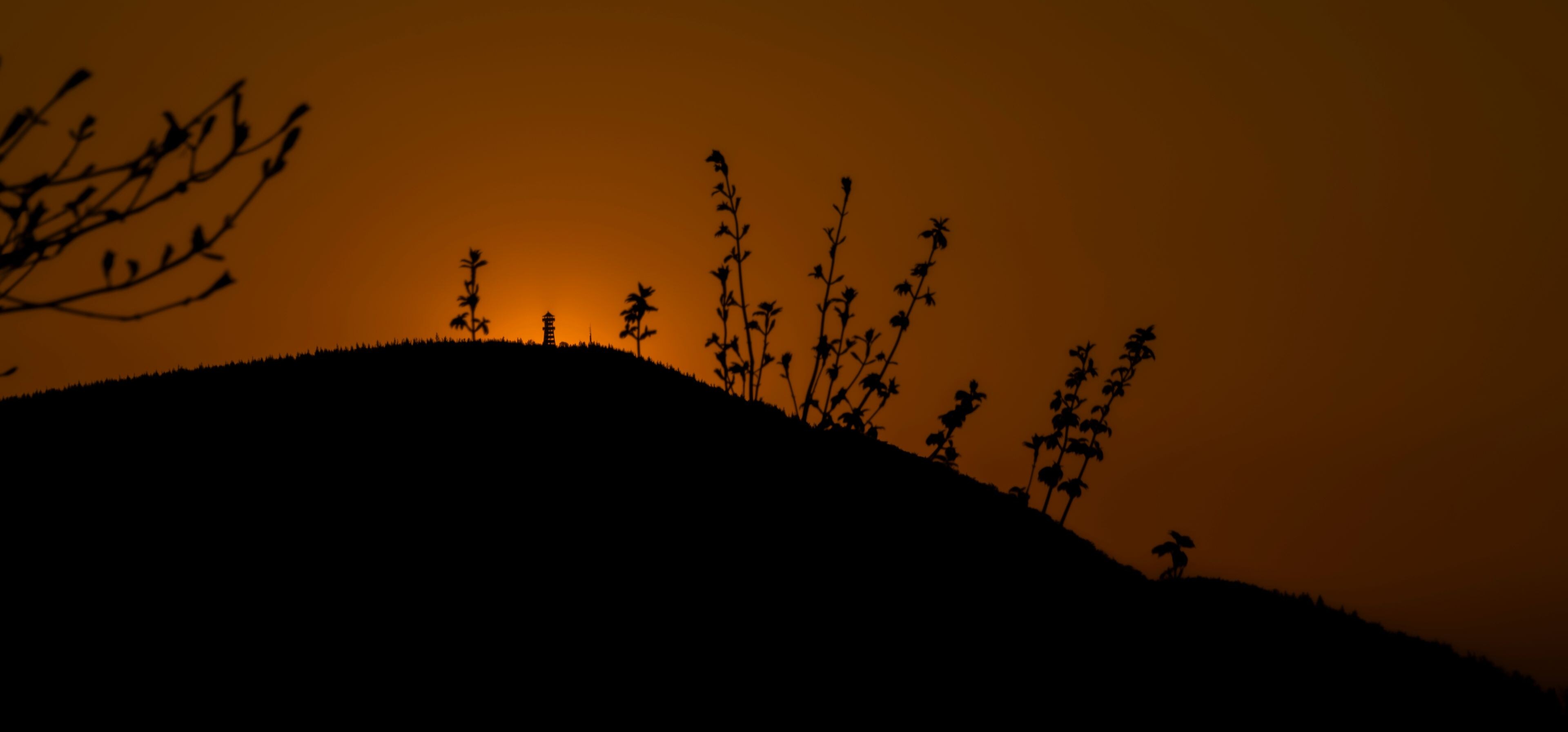 Silhouette of big hill Velky Javornik with observation tower and orange sunset