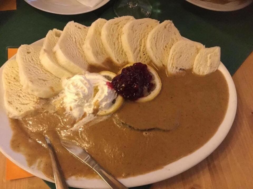 A plate of sliced bread with a creamy spread, a dollop of whipped cream, and a slice of lemon.