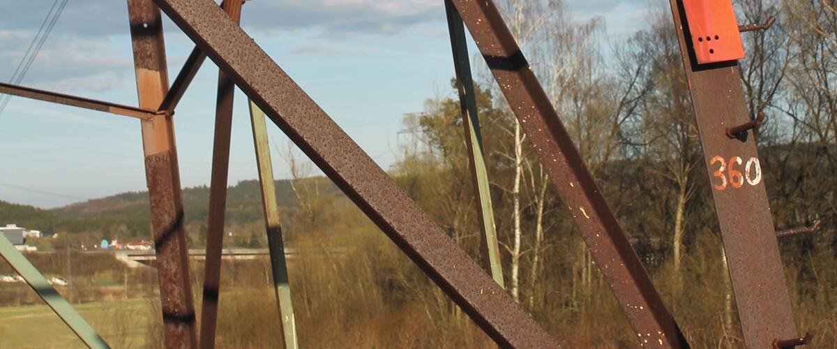 A rusted metal structure with a warning sign and the number 360.