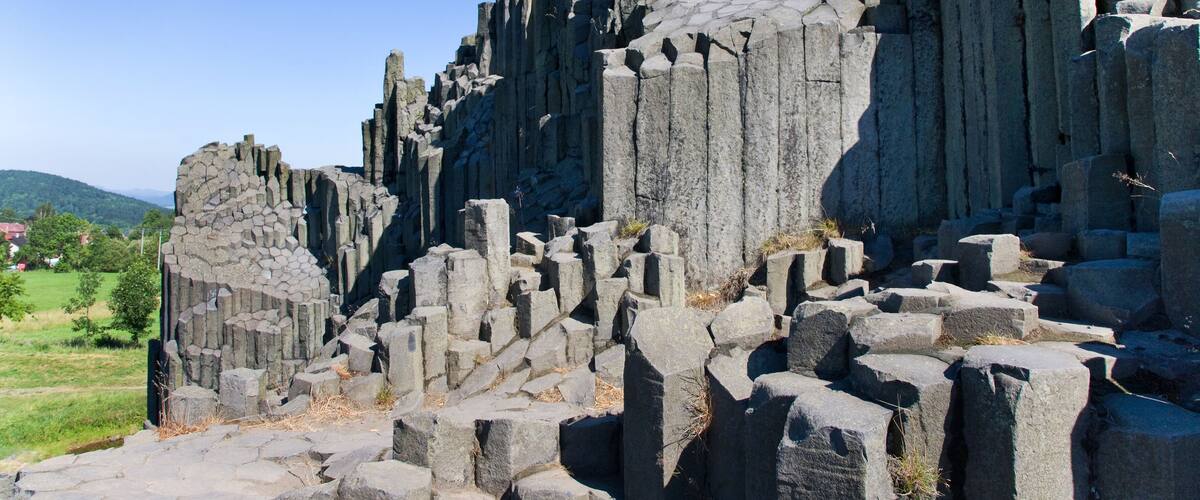 A rocky ruin with tall, jagged structures and a clear blue sky.