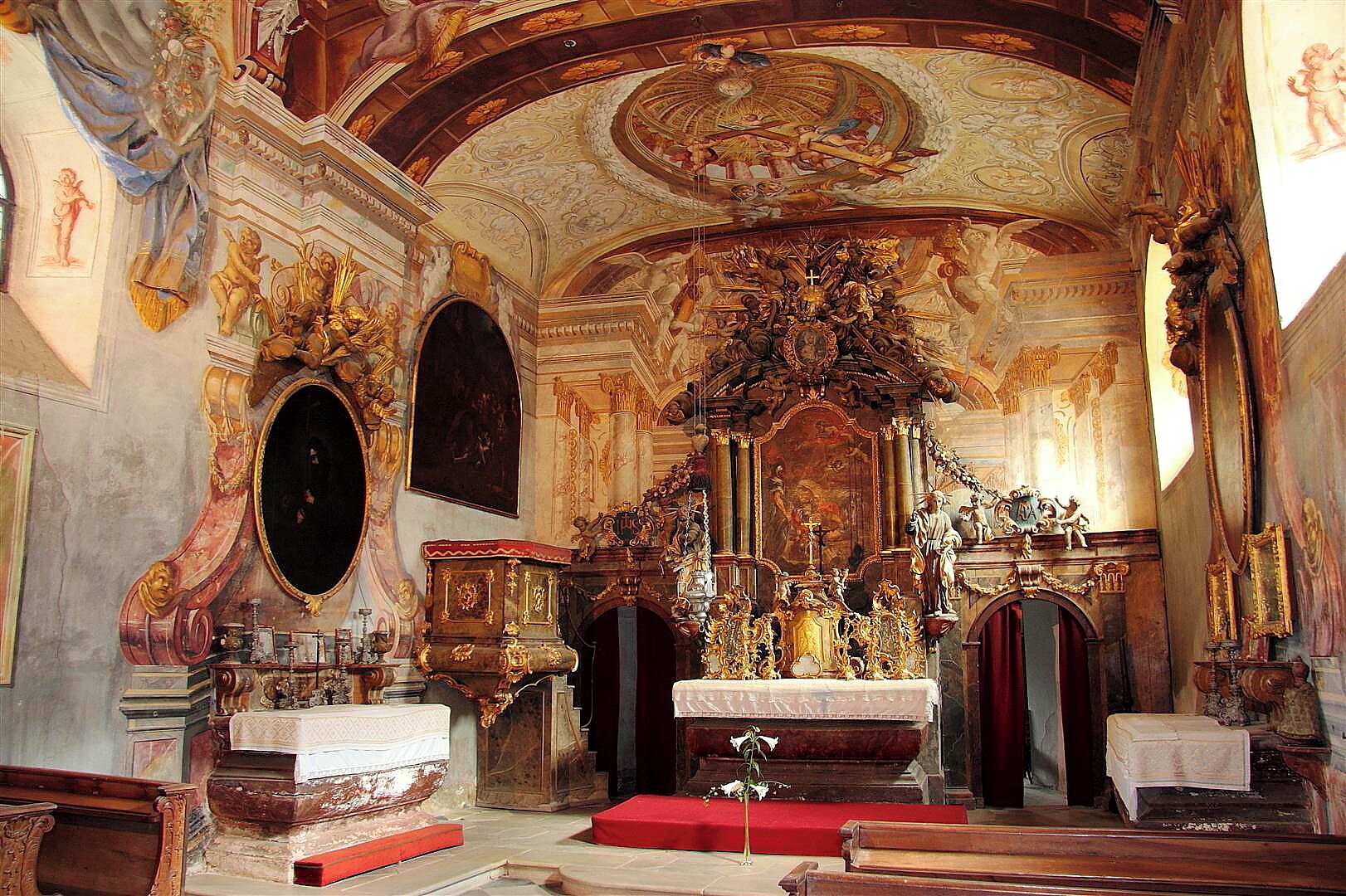 An ornate church interior with a large altar, detailed frescoes, and classical architecture.