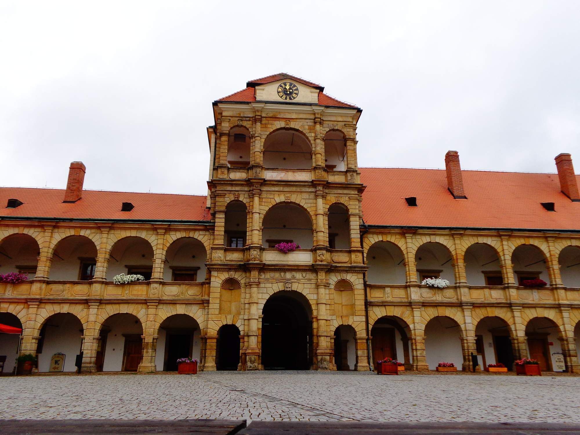 A historic building with a central tower, arched windows, and a tiled roof.