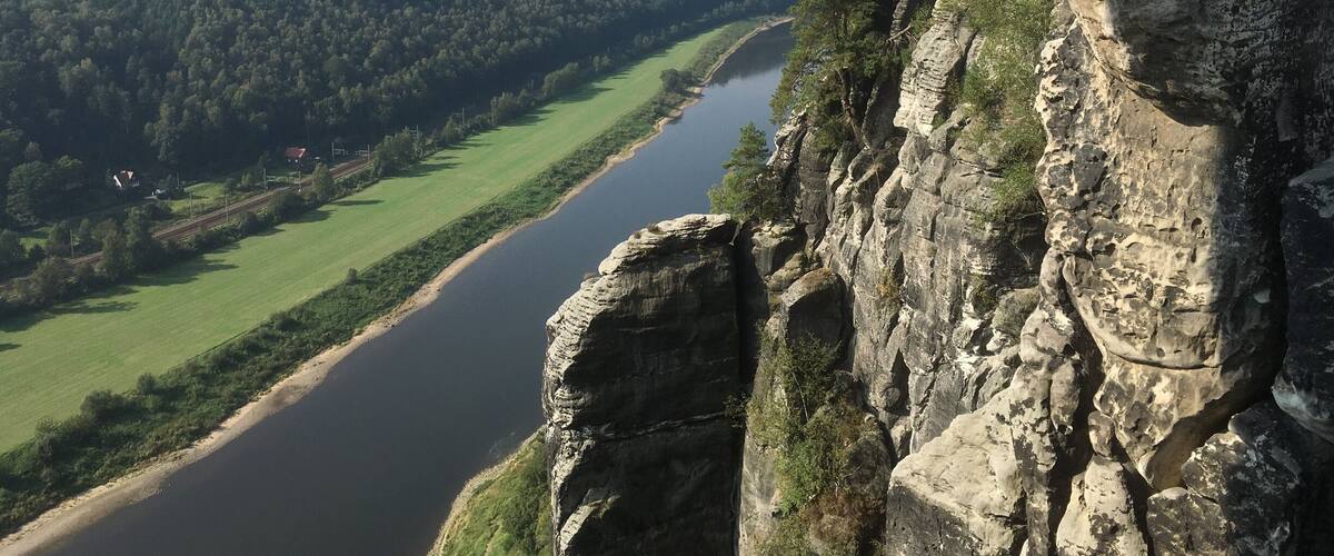 A river winding through a valley, surrounded by dense forests and rocky cliffs.