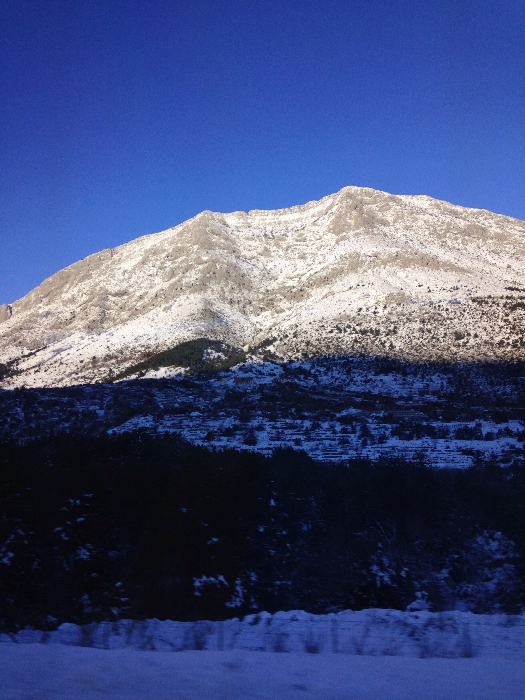 A snow-covered mountain with a clear blue sky.