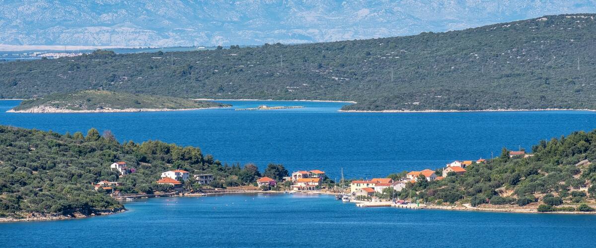 A coastal town with a clear view of snow-capped mountains in the background.