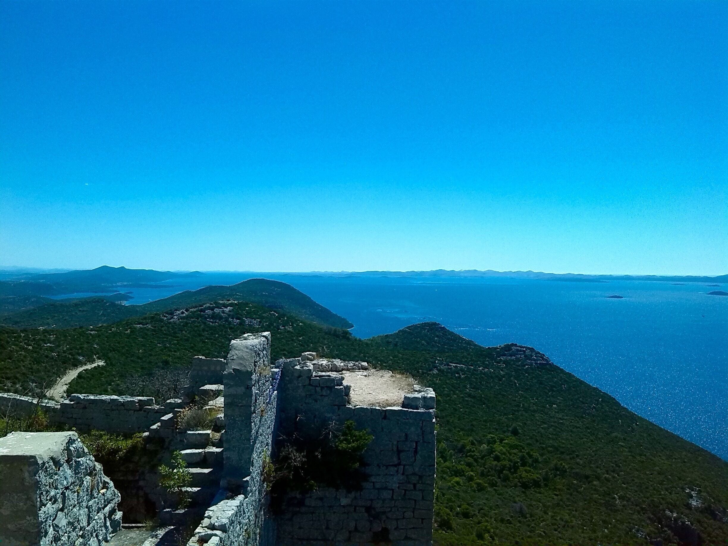 A coastal landscape with ruins and a clear blue sky.