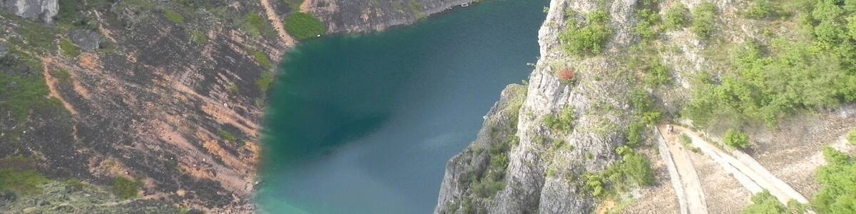 Un paysage montagneux avec une vallée profonde et un petit plan d’eau.