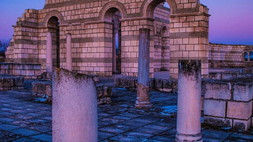 Ancient ruins with arched doorways and columns.