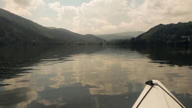 A calm lake with mountains in the background and a boat in the foreground.