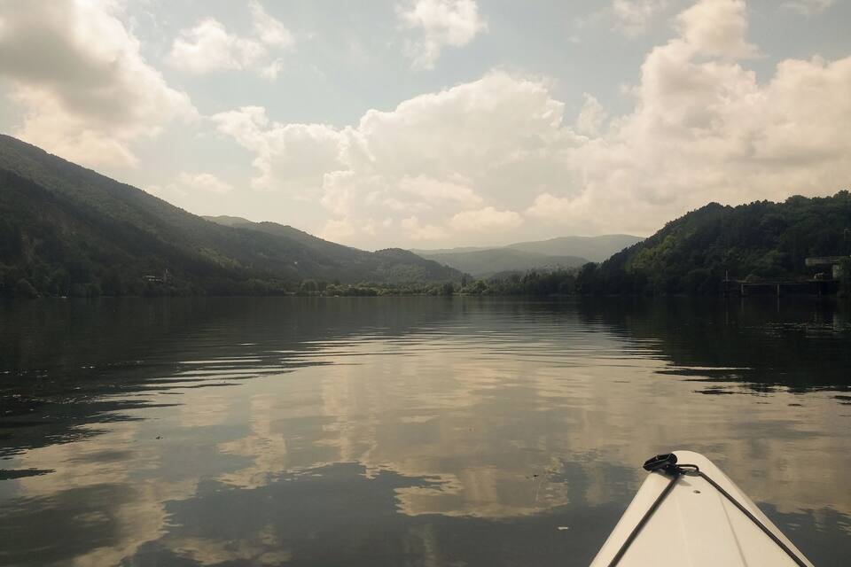 Un lago tranquilo con montañas al fondo y un bote en primer plano.