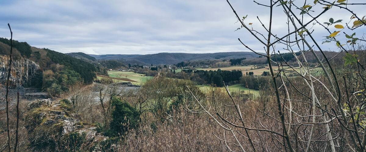 A valley with a river, hills, and scattered buildings.