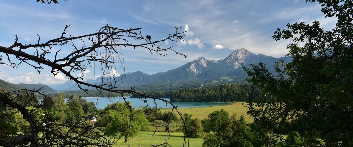 A mountainous landscape with a lake and green fields.