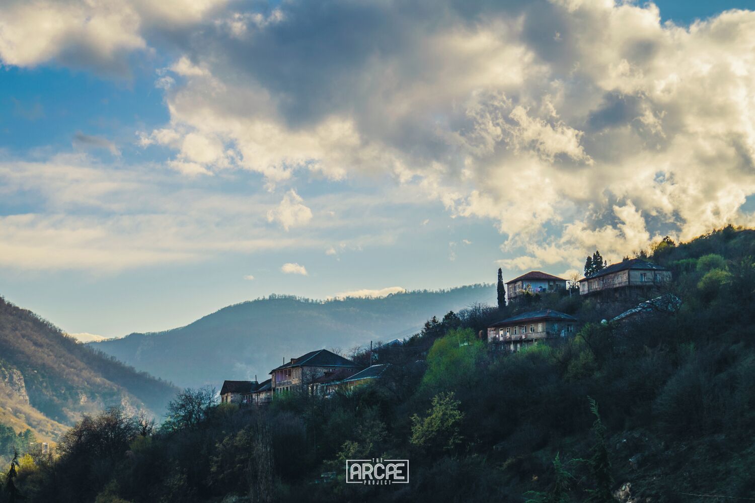 A mountainous landscape with several houses perched on the hillside.