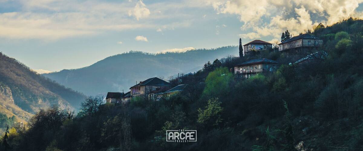 A mountainous landscape with several houses perched on the hillside.