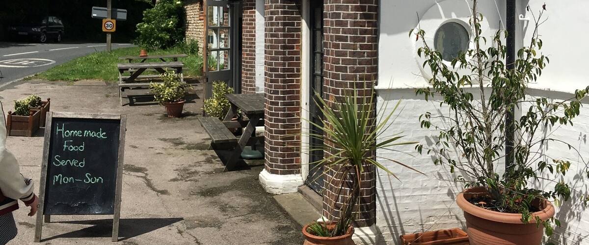 A quaint building with a sign reading "Home made Food Served Mon-Sun" and a speed limit sign of 30.