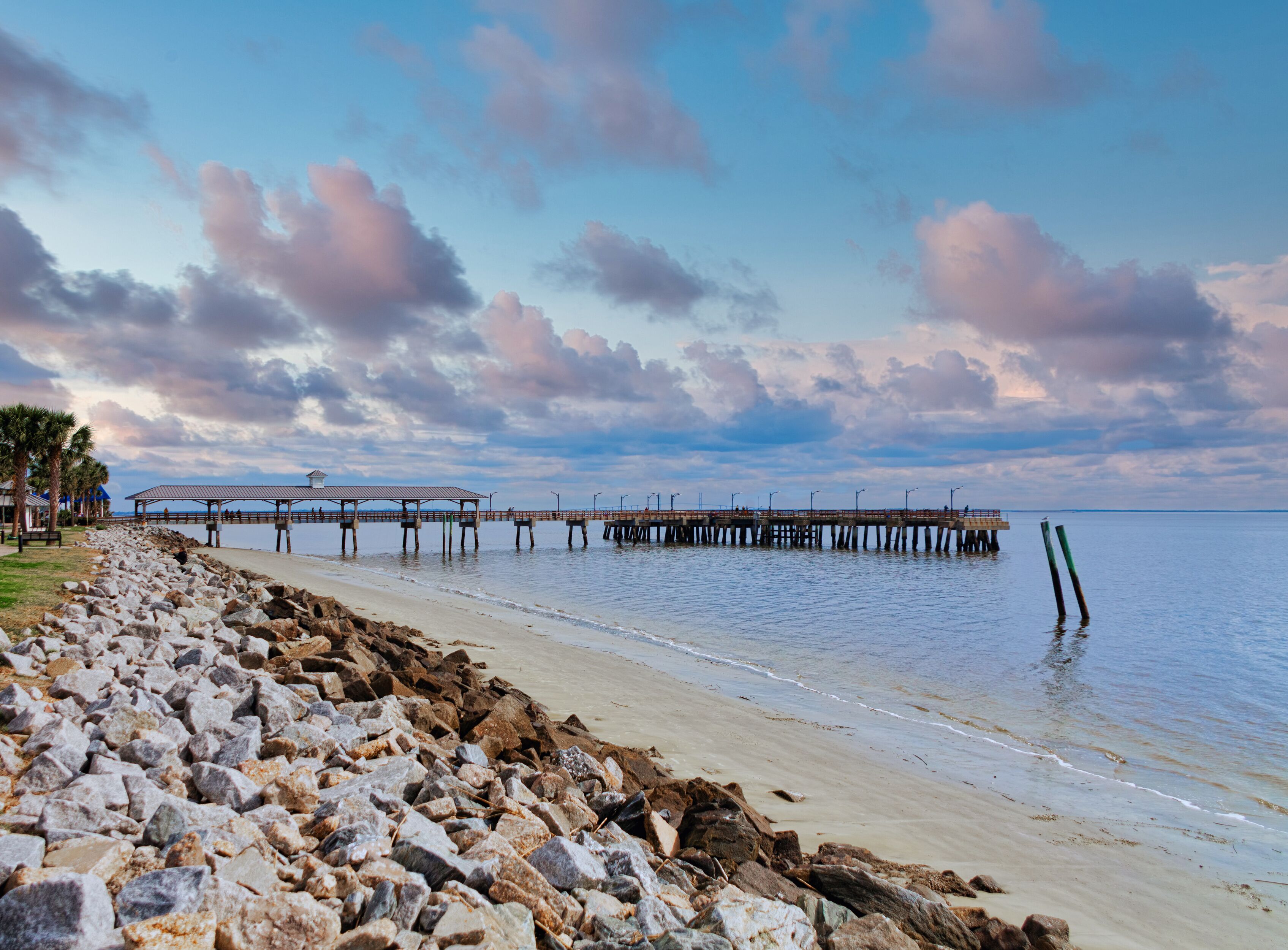 An old fishing pier on St Simons Island beyond rock seawall