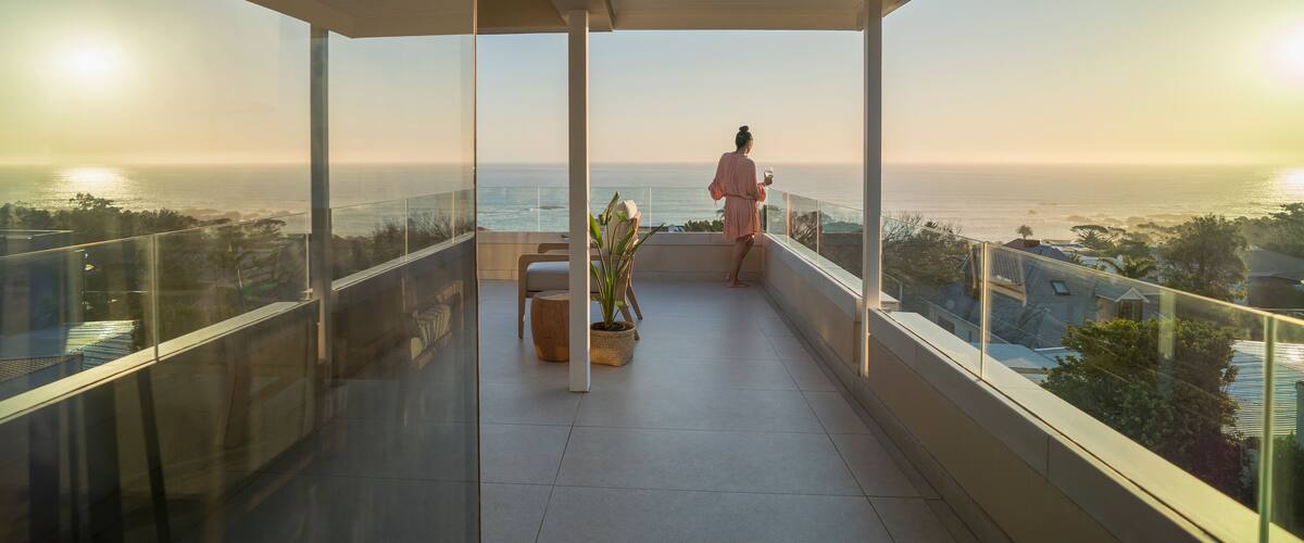 A balcony with a view of the ocean and a sunset.